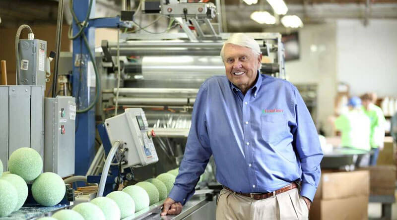 A picture of a Manager or an Owner smiling, beside him is the company machine.