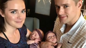 A happy parents holding their twins.