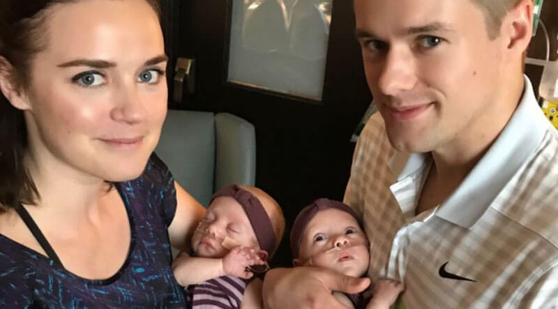 A happy parents holding their twins.